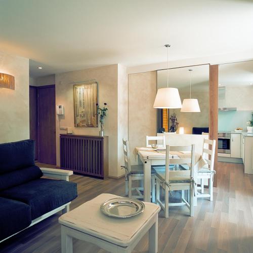 un soggiorno con tavolo e una sala da pranzo di Apartamentos la Torreta del Llac a Puigcerdà