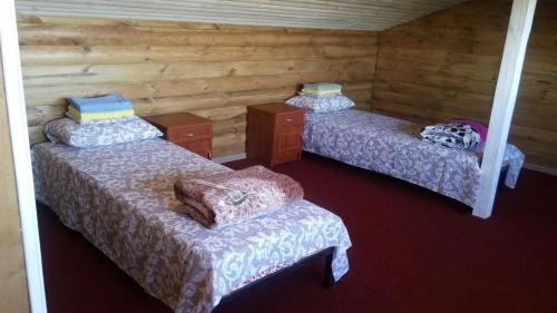 three beds in a room with wooden walls at Apart hotel Alicante in Zatoka