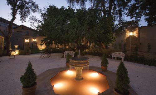 a courtyard with a fountain and trees and lights at Posada Real Casa de Tepa in Astorga