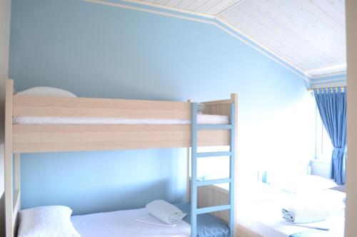 a bunk bed with a ladder in a room at Open Doors Bed & Breakfast in Shkodër