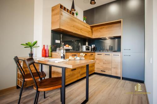 a kitchen with a wooden table and chairs at Ameri Apartments Tbilisi in Tbilisi City