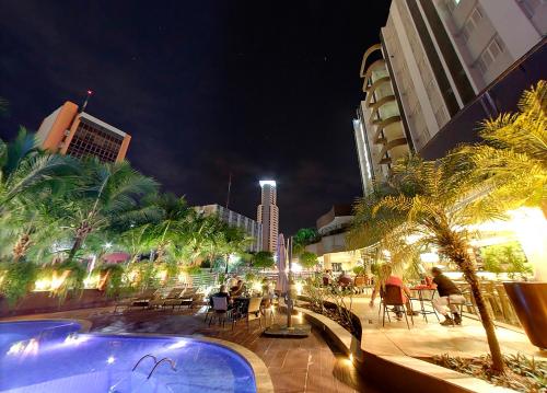 uma piscina numa cidade à noite em Hotel Taiamã em Cuiabá