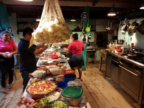 a group of people standing in a kitchen preparing food at Tortugal Boutique River Lodge in Rio Dulce