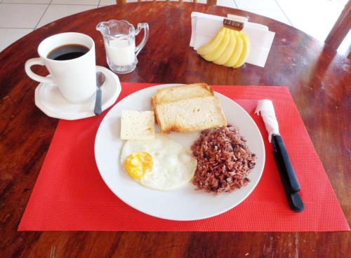 a plate with eggs bread and beans and a cup of coffee at Hospedaje y Cafe Ruiz in Granada