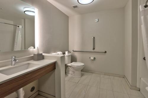 a white bathroom with a toilet and a sink at Holiday Inn Express & Suites Broomfield, an IHG Hotel in Broomfield