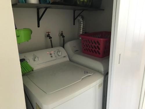 a kitchen with a washing machine and a red basket at Playa Chacá in Progreso