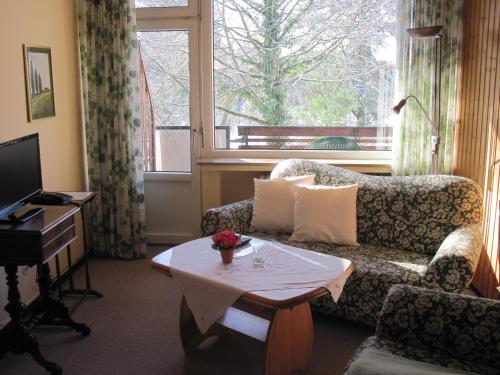 sala de estar con sofá, mesa y ventana en Hotel-Café "Schauinsland", en Horn-Bad Meinberg