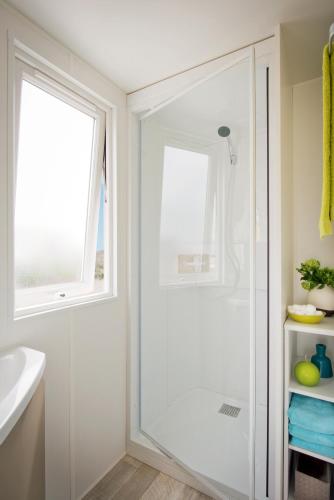 une salle de bain blanche avec une douche et un lavabo dans l'établissement Le Goh Velin, à Saint-Gildas-de-Rhuys