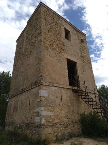 an old brick building with a staircase on the side at Can Quilis in Pontós