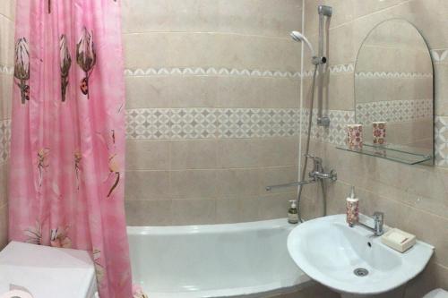 a bathroom with a sink and a shower curtain at Apartment on Dzerzhinskogo 62 in Tyumen