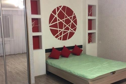 a bedroom with a bed with red pillows on it at Apartment on Dzerzhinskogo 62 in Tyumen