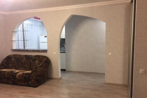 a living room with a couch and an archway at Apartment on Dzerzhinskogo 62 in Tyumen