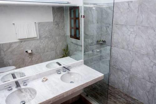 a bathroom with two sinks and a glass shower at Hotel Santa Fe in Puerto Escondido