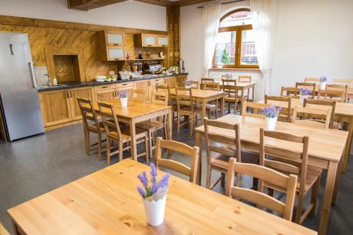 a restaurant with wooden tables and chairs and a kitchen at Tatrzańska Przystań in Zakopane