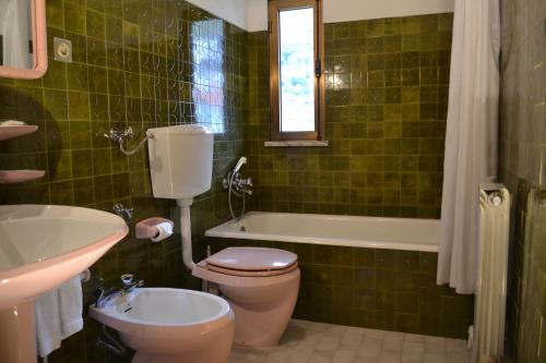 uma casa de banho com um WC, uma banheira e um lavatório. em Casa da Ponte em Alvoco da Serra