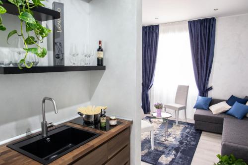 a kitchen and living room with a sink and a couch at Il Magnificus Boutique in Rome