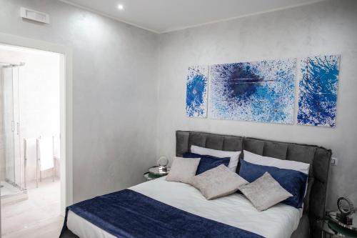 a bedroom with a bed with blue and white pillows at Il Magnificus Boutique in Rome