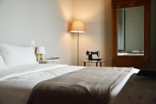 モンテ・サン・サヴィーノにあるNonno Gino suiteのベッドルーム(ベッド1台、ランプ、鏡付)