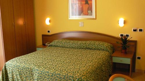 - une chambre avec un lit et une couette verte dans l'établissement Hotel Mario, à San Benedetto del Tronto
