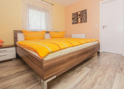 a bedroom with a large bed with yellow sheets at Spreewaldapartments-Kossatz in Lübben