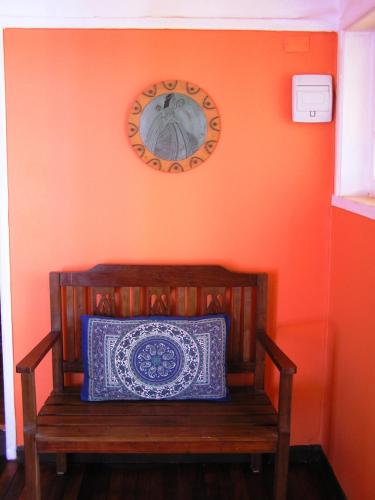 a bench in a room with a clock on the wall at Casa Violeta Limón in Valparaíso