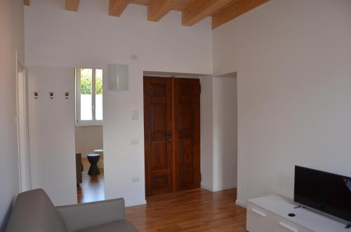 a living room with a wooden door and a television at Palazzo Oltre in Arco