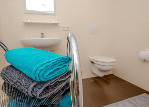 a bathroom with a sink and a toilet and towels at Spreewaldapartments-Kossatz in Lübben