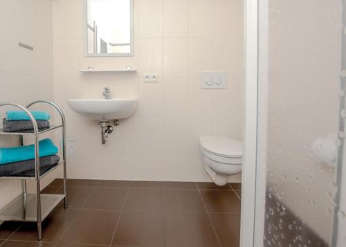 a white bathroom with a sink and a toilet at Spreewaldapartments-Kossatz in Lübben