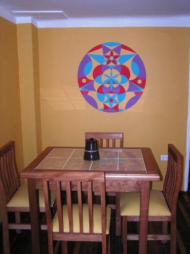 a dining room table with chairs and a stained glass window at Casa Violeta Limón in Valparaíso