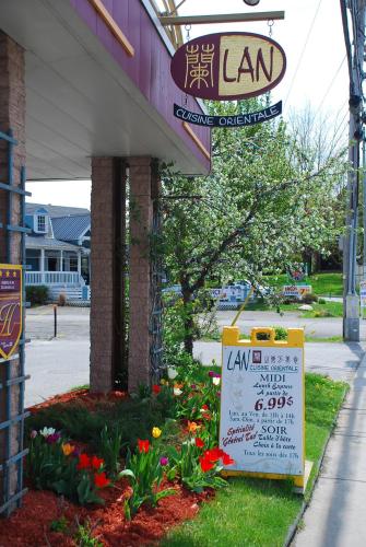 a sign in front of a store with flowers at Auberge du Grand Lac in Magog-Orford