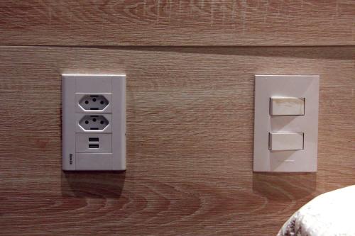 two electrical switches are on a wooden wall at Estudio Itaipava in Itaipava