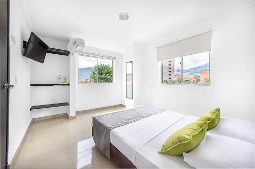 een witte slaapkamer met een bed en 2 ramen bij Ayenda 1219 Park 6 in Medellín