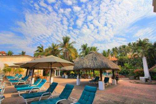 a group of chairs and umbrellas on a patio at Hotel Santa Fe in Puerto Escondido