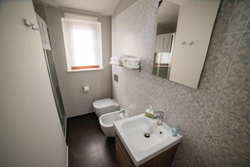 a bathroom with a white sink and a toilet at Casa Nicole in Castelbuono