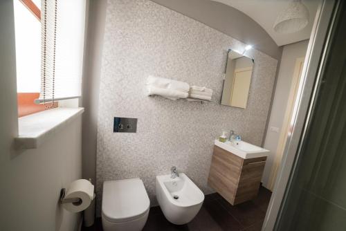 a bathroom with a white toilet and a sink at Casa Nicole in Castelbuono