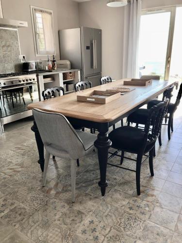 a kitchen with a large wooden table and chairs at Les Villas MarInCelu in Porto Pollo