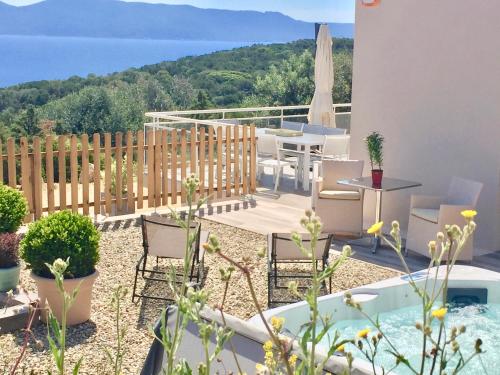 a patio with chairs and a table and a fence at Les Villas MarInCelu in Porto Pollo