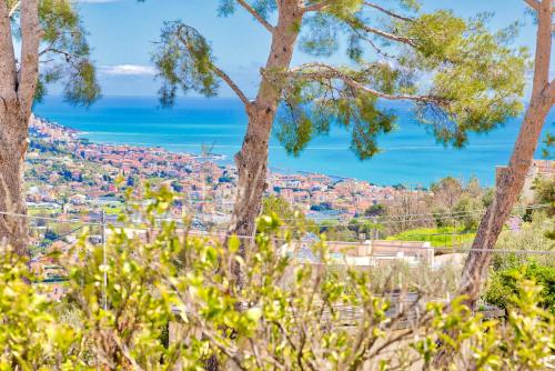 a view of a city from behind trees at Casa Mara - Diano Serreta in Diano Marina