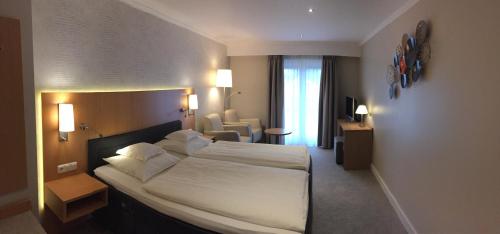 ein Schlafzimmer mit einem großen weißen Bett in einem Hotelzimmer in der Unterkunft Landhotel Alberts in Heijenrath