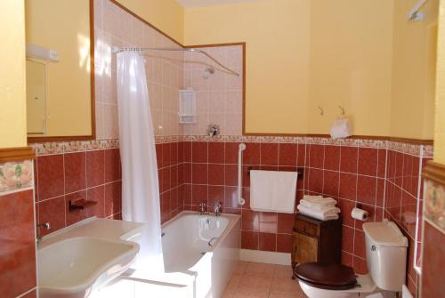 uma casa de banho com uma banheira, um WC e um lavatório. em Kilburn House B&B em Milltown