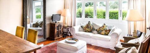 a living room with white furniture and a large mirror at The Snug in Hastings