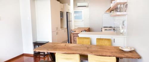 a small kitchen with a wooden table and chairs at The Snug in Hastings