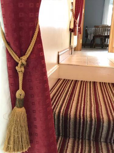a staircase with a red curtain and a carpet at Greencastle in Kilkeel