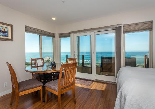 a bedroom with a dining room table with a view of the ocean at Little Sur Inn in Cambria