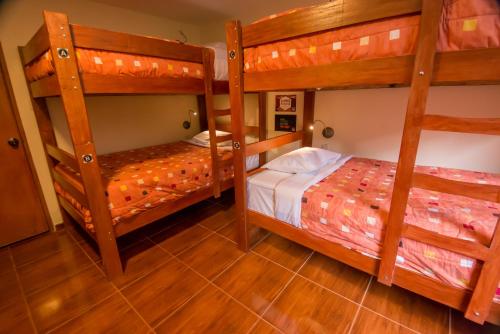 two bunk beds in a room with wooden floors at Casa Machu Picchu Hostel in Machu Picchu