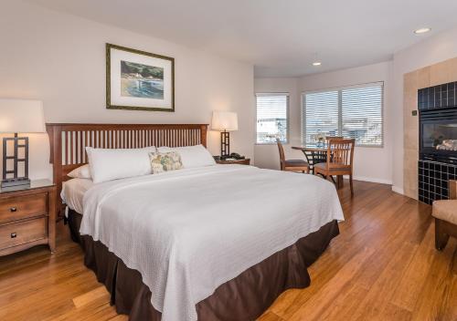 a bedroom with a large bed and a table and chairs at Little Sur Inn in Cambria
