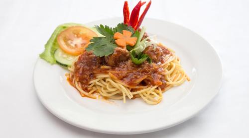 a plate of spaghetti with meat sauce and vegetables at Hotel Seri Malaysia Rompin in Kuala Rompin