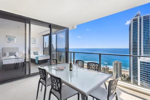 a white dining room with a view of the ocean at Holiday Holiday Circle On Cavill Apartments in Gold Coast