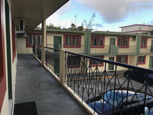 uma varanda de um edifício de apartamentos com uma cerca em 2 BEDROOM / 1 BATH ONLY 9 MILES TO NAVY BASE em Sinajana