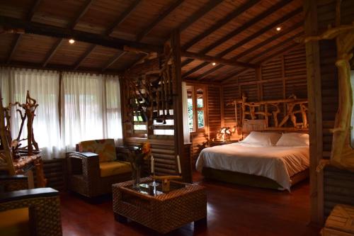 a bedroom with a bed and a chair in a room at La Finestra Spa Hotel Boutique in La Vega